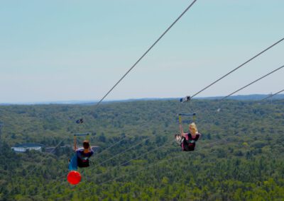 Brother and sister flying together on HighFlyer Zipline at Foxwoods Resort Casino, Connecticut