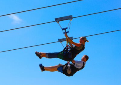 Couple flying mid-air side by side on HighFlyer Zipline at Foxwoods Resort Casino, Connecticut